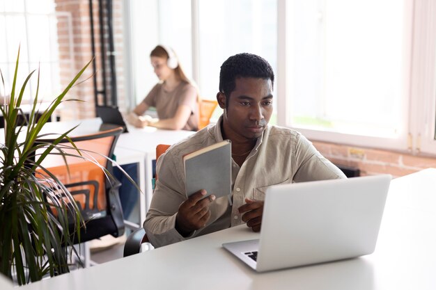 Uomo a tiro medio al lavoro con laptop