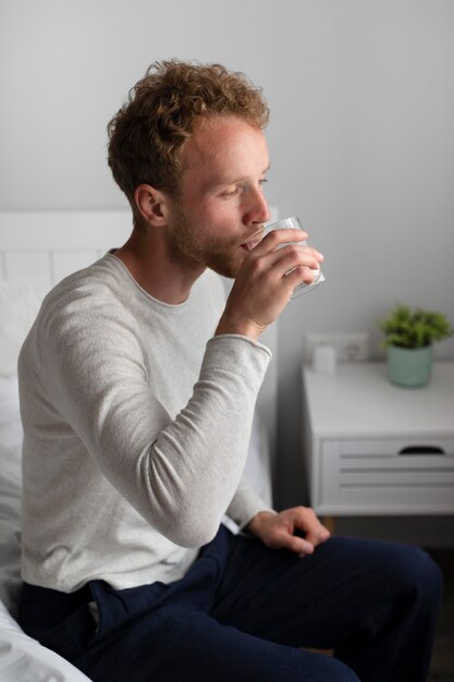 Uomo a tiro medio che beve acqua