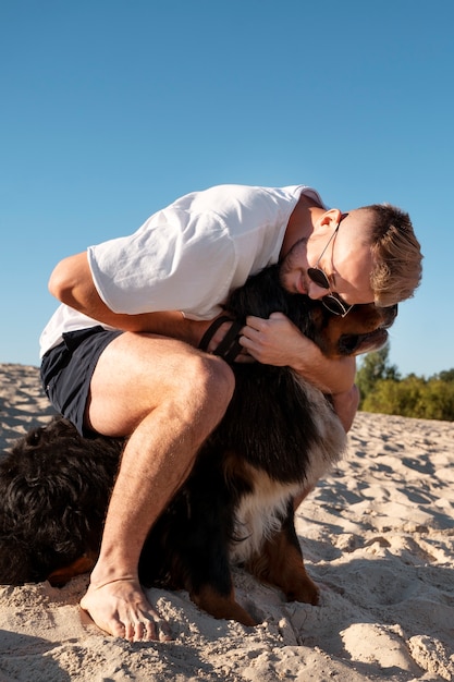 Uomo a tutto campo che abbraccia un cane carino