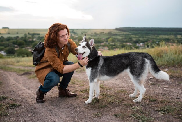 Uomo a tutto campo che accarezza un cane carino