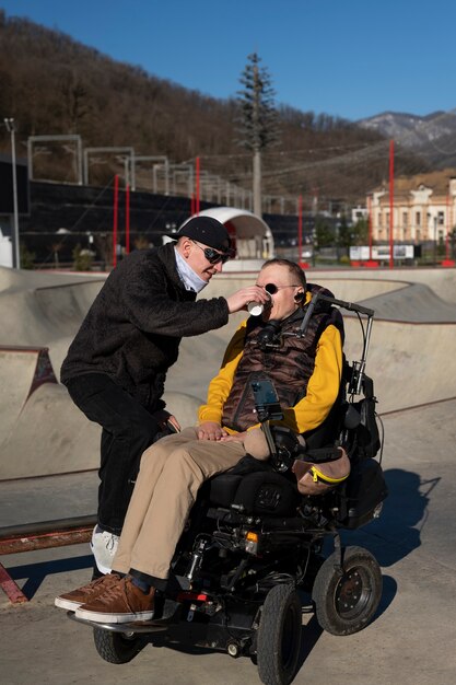 Uomo a tutto campo che aiuta un amico disabile