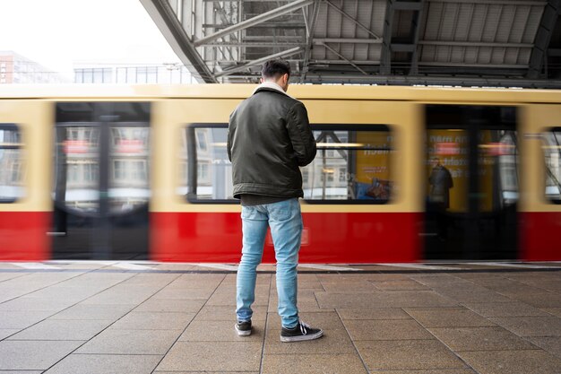 Uomo a tutto campo che aspetta il treno