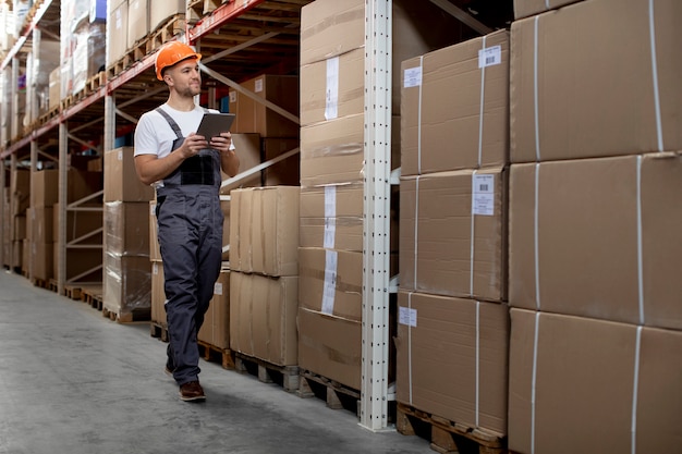 Uomo a tutto campo che lavora nel magazzino logistico