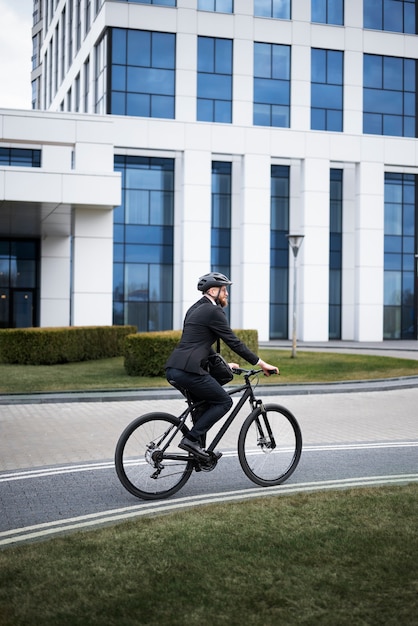 Uomo a tutto campo che va a lavorare in bicicletta