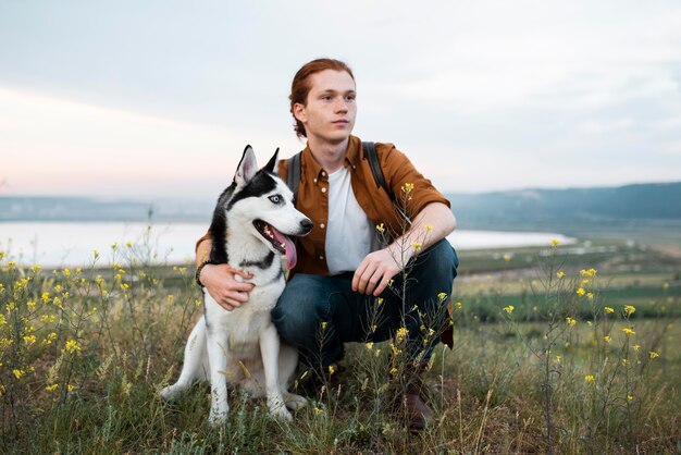 Uomo a tutto campo che viaggia con il cane in natura