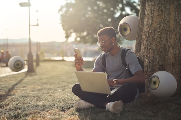 Uomo a tutto campo con laptop e smartphone