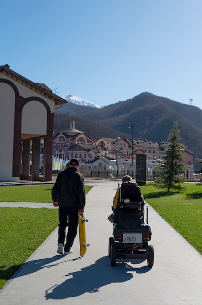 Uomo a tutto campo e amico disabile all'aperto