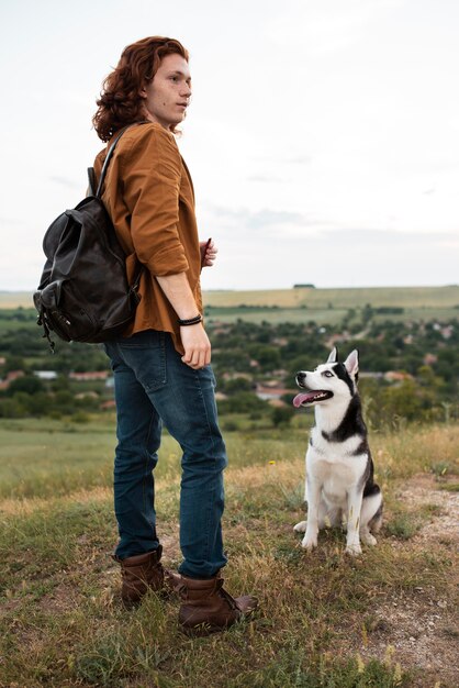 Uomo a tutto campo e simpatico husky