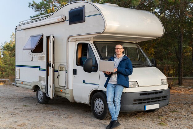 Uomo a tutto campo in piedi vicino al camper