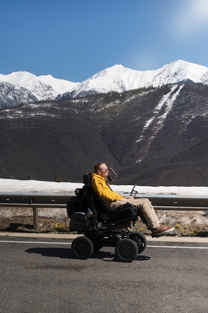 Uomo a tutto campo in sedia a rotelle che ammira la natura