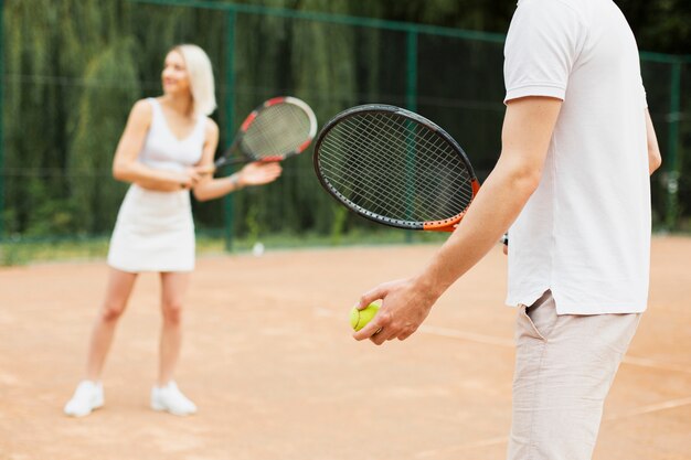 Uomo adatto e donna che esercitano tennis