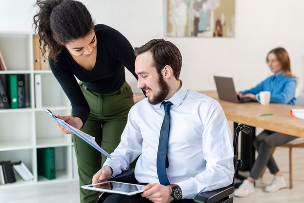 Uomo adulto e donna che lavorano insieme in ufficio