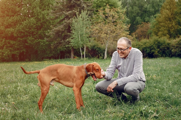 Uomo adulto in un parco estivo con un cane