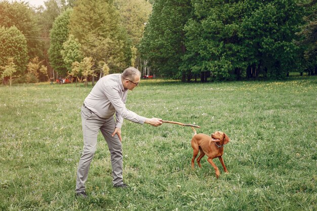 Uomo adulto in un parco estivo con un cane