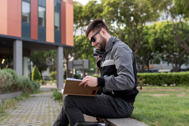 Uomo adulto seduto sulla panchina e apprendimento