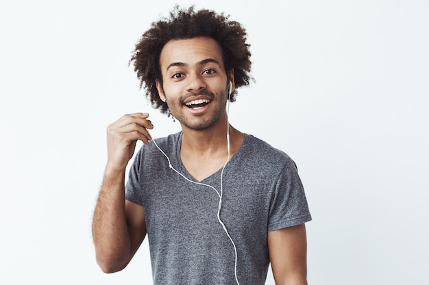 Uomo africano felice che mette fuori sorridere della cuffia.