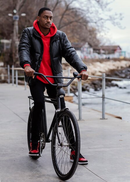 Uomo afro-americano in sella alla sua bicicletta
