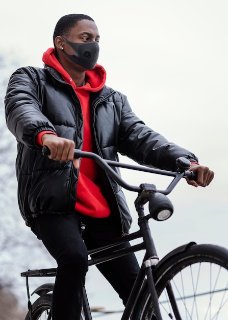 Uomo afro-americano in sella alla sua bicicletta