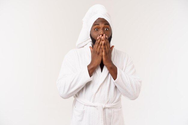 Uomo afroamericano che indossa un accappatoio con sorpresa e emozione felice isolato su sfondo bianco