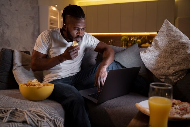 Uomo afroamericano che mangia a tarda notte