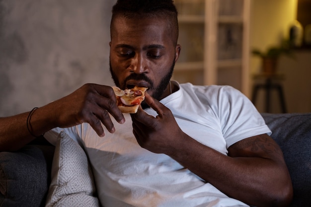 Uomo afroamericano che mangia a tarda notte