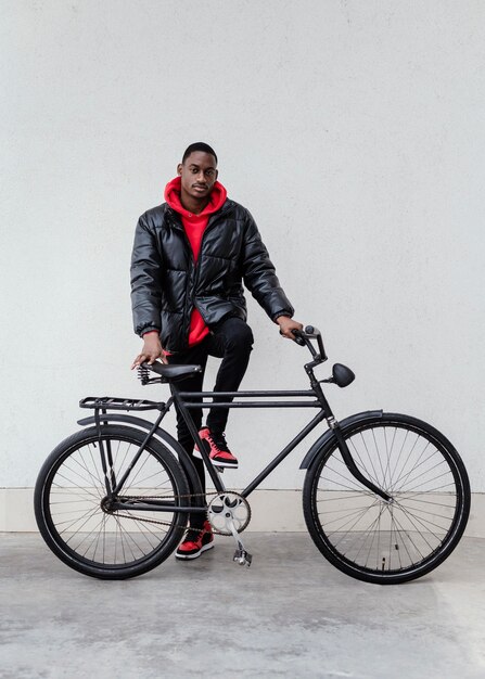 Uomo afroamericano che tiene la sua bicicletta davanti a lui