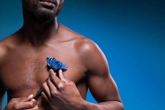 Uomo afroamericano che tiene un fiore blu