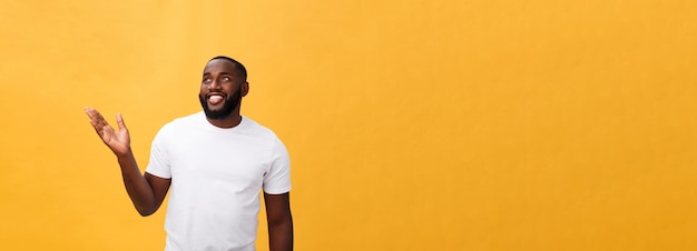 Uomo afroamericano con la barba che mostra lato della mano isolato sopra fondo giallo