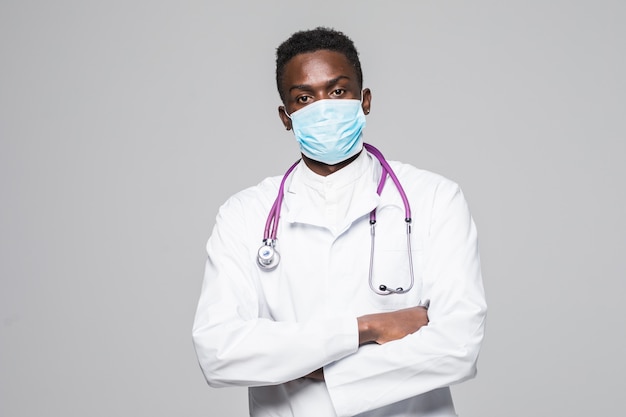 Uomo afroamericano di medico con la maschera isolata su fondo grigio