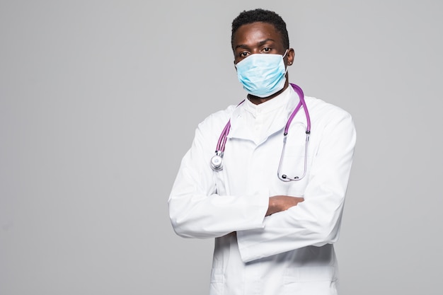 Uomo afroamericano di medico con la maschera isolata su fondo grigio