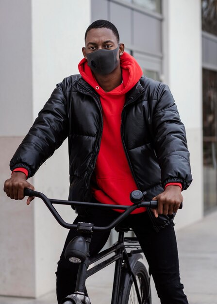 Uomo afroamericano di tiro medio e la sua bicicletta