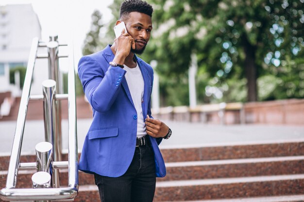 Uomo afroamericano in giacca blu utilizzando il telefono