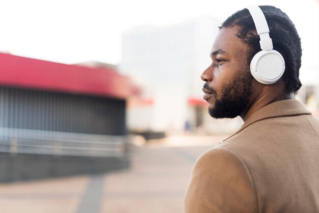 Uomo afroamericano lateralmente che ascolta la musica tramite le cuffie