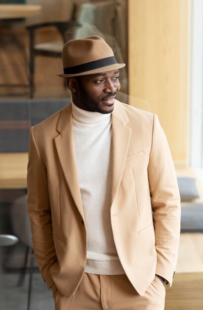 Uomo afroamericano moderno in vestito beige