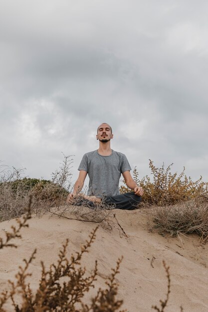 Uomo all'aperto che fa yoga