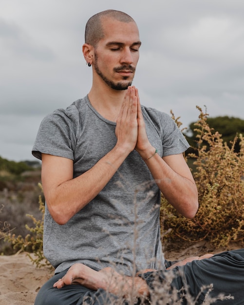 Uomo all'aperto che fa yoga