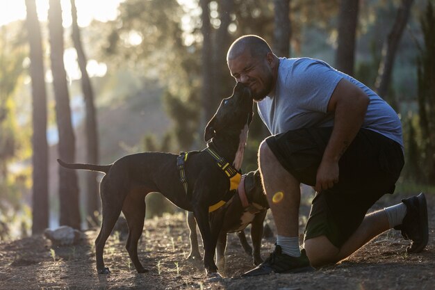 Uomo all'aperto in una sessione di addestramento del cane con due cani