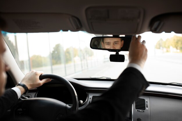 Uomo alla guida della sua auto elegante per i servizi di taxi