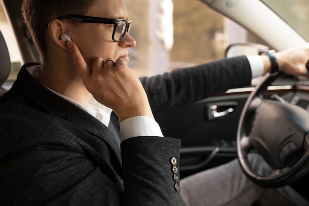 Uomo alla guida della sua auto elegante per i servizi di taxi