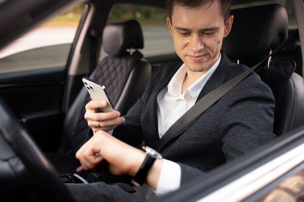 Uomo alla guida della sua auto elegante per i servizi di taxi