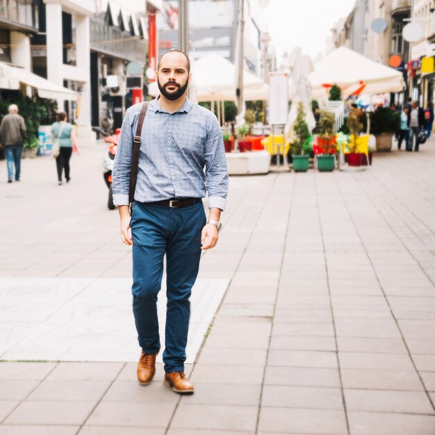 Uomo alla moda che cammina per strada