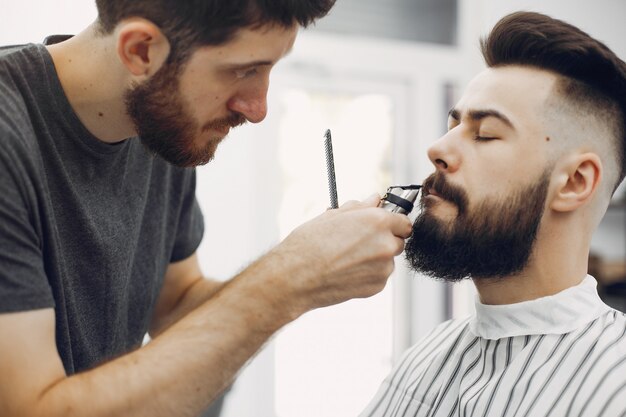 Uomo alla moda che si siede in un barbiere