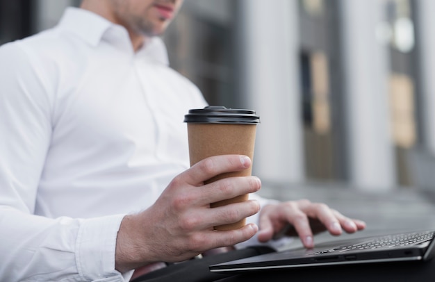 Uomo alla moda che tiene tazza di caffè