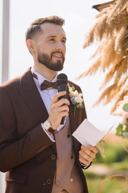 Uomo alla moda con il microfono che parla il giorno del matrimonio