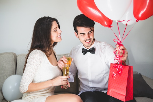 Uomo alla moda con palloncini e un sacchetto rosso