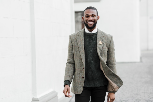 Uomo alla moda di smiley che posa all'aperto