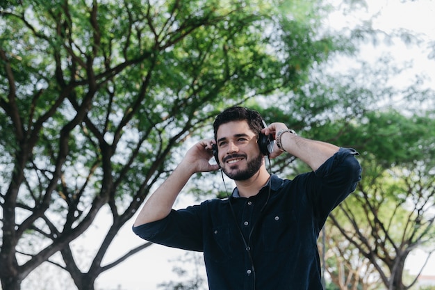 Uomo allegro che gode della musica nel parco