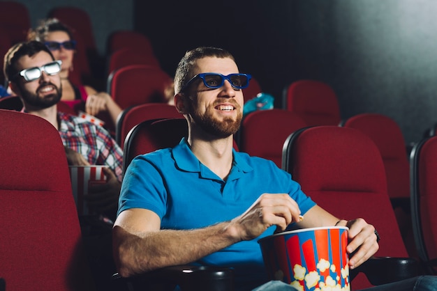 Uomo allegro che guarda film con popcorn
