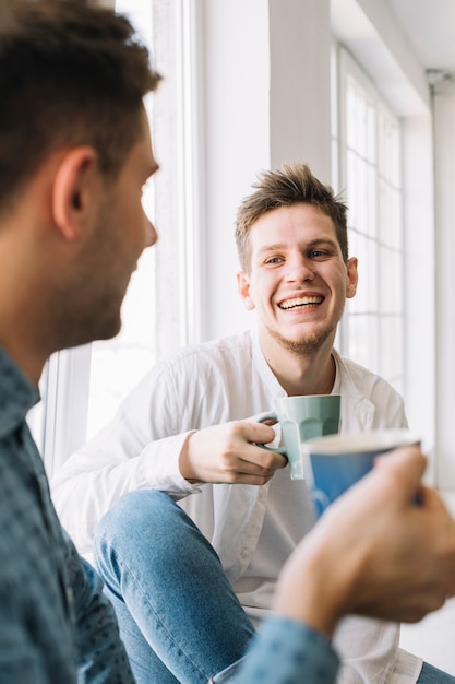 Uomo allegro con colazione del mattino con il suo amico