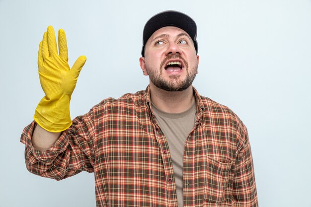 Uomo allegro delle pulizie con guanti di gomma in piedi con la mano alzata